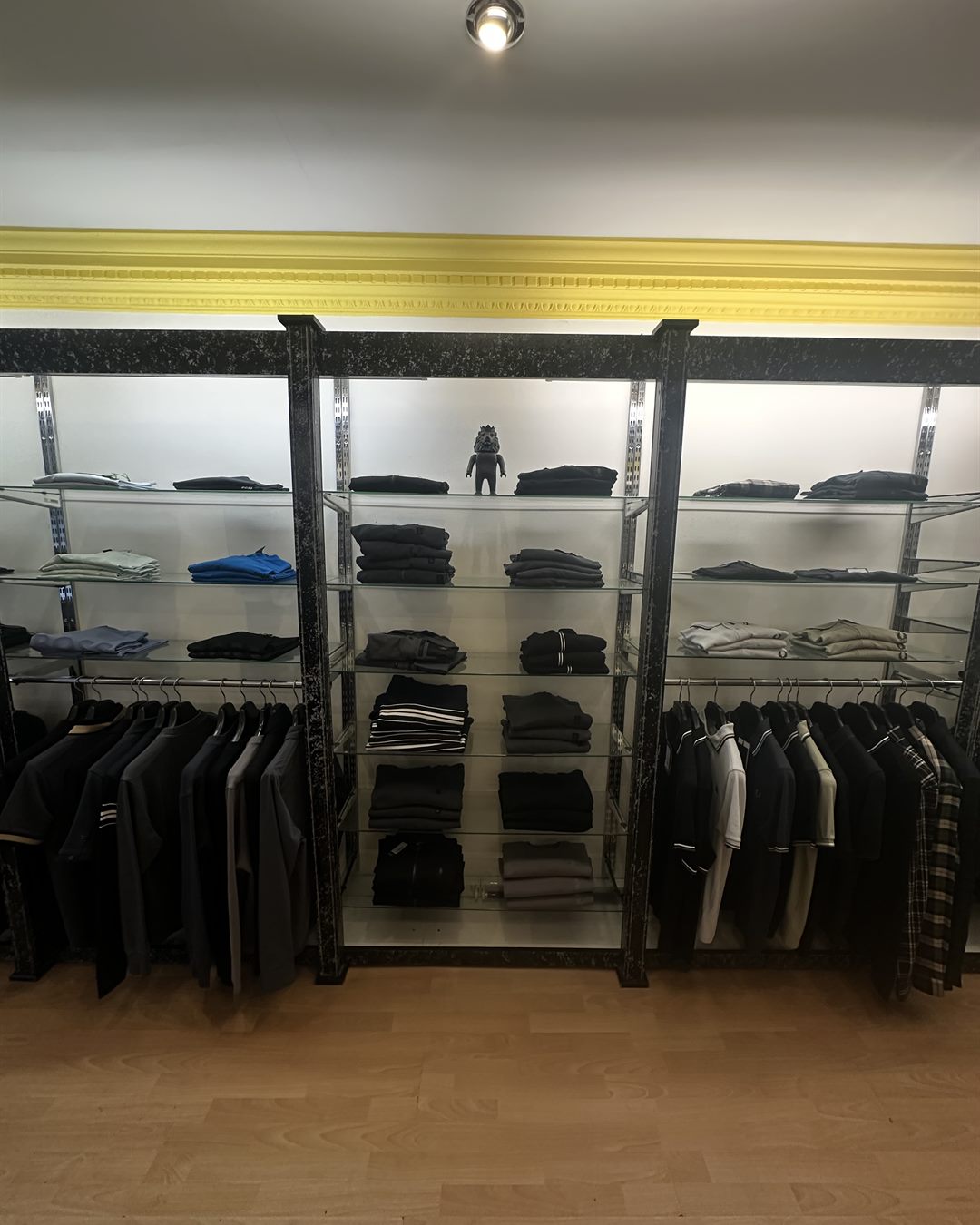 Shelves of folded knitwear and rails of polos inside Icon Menswear